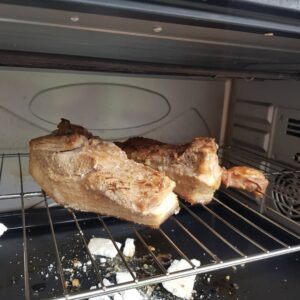 Membalik siobak babi panggang di dalam oven